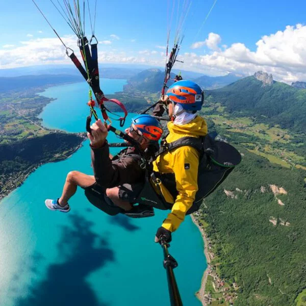 Pilotage d'un parapente au dessus du lac bleu turquoise d'Annecy