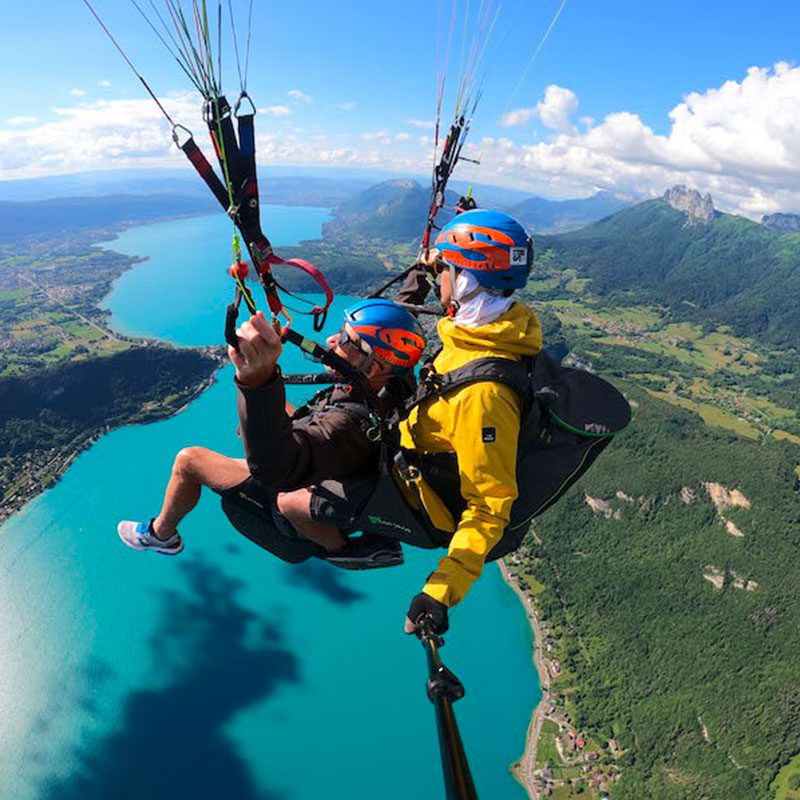 Pilotage d'un parapente au dessus du lac bleu turquoise d'Annecy